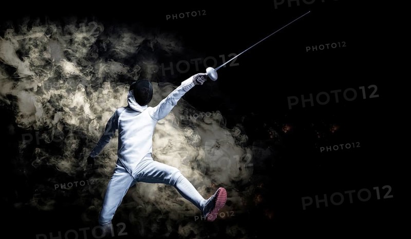 The fencer moves forward with a sword in his hand. Sport concept.