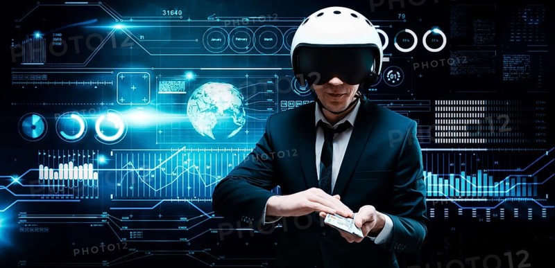 Portrait of a businessman in a suit and aviator helmet. He holds a bundle of hundred-dollar bills in front of him. Business concept.