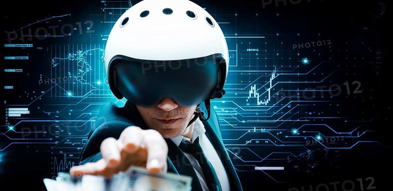 Portrait of a businessman in a suit and aviator helmet. He is trying to reach a pack of hundred-dollar bills. Business concept.