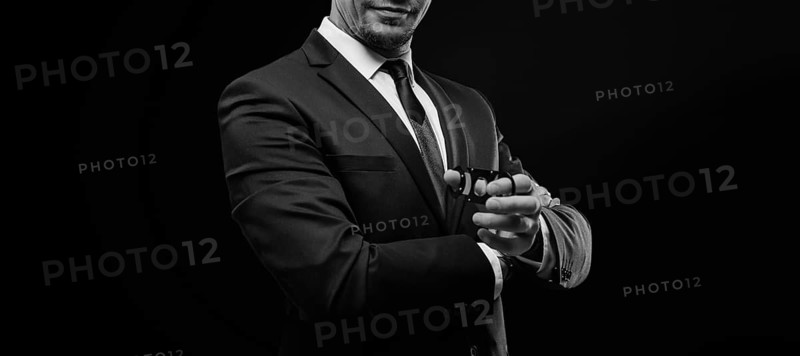 Image of an adult stylish man in a suit with a cigar. Cigar clubs concept.