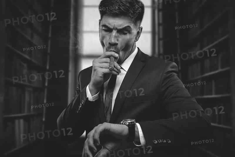 Portrait of a stylish man in a suit with a cigar. Business concept.