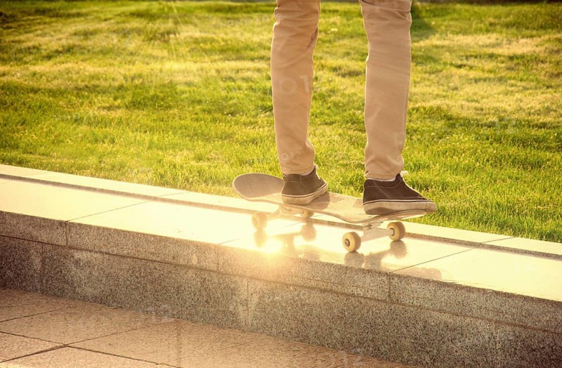 Desperate skateboarder performs dangerous movement on the skateboard at sunset