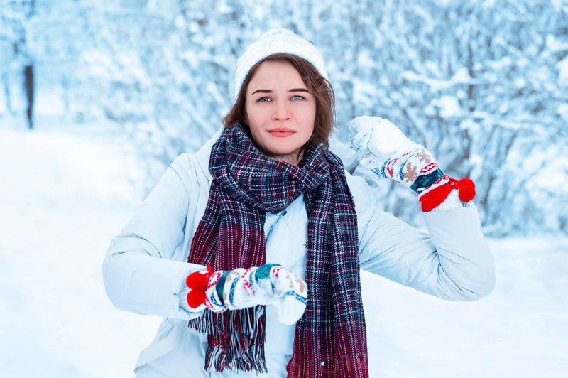 Portrait of a beautiful girl throwing a snowball. Concept for Christmas holidays