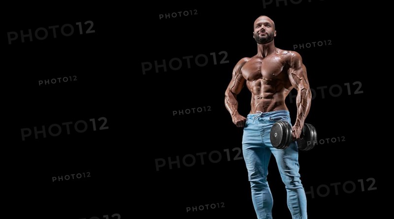 Isolated muscular man on a black background. Bodybuilding and fitness concept. Panorama.