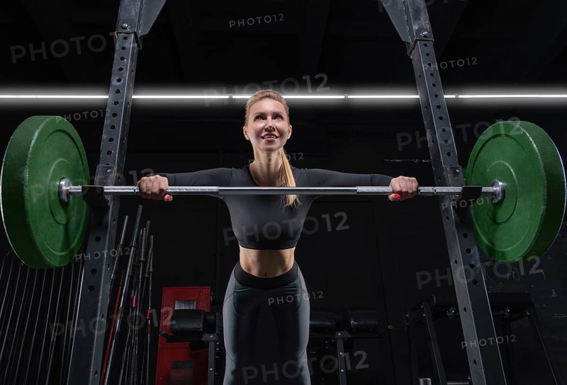 Beautiful tall blonde is doing push-ups from the bar in the gym. Fitness and bodybuilding concept.