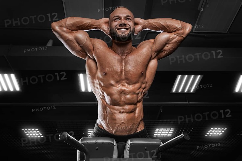 Professional athlete performs hyperextension in the gym. Bodybuilding