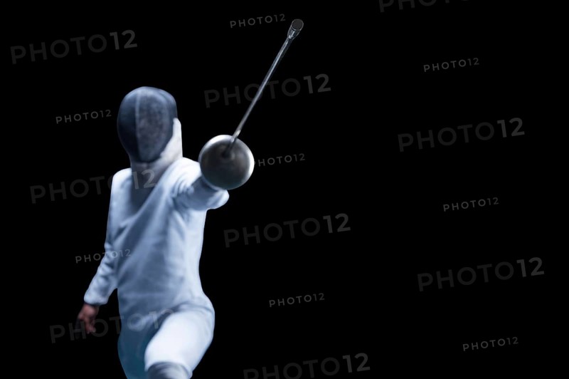 The fencer moves forward with a sword in his hand. Sport concept.