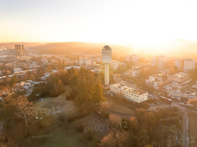 Elevated view of a water tower and the cityscape at sunrise