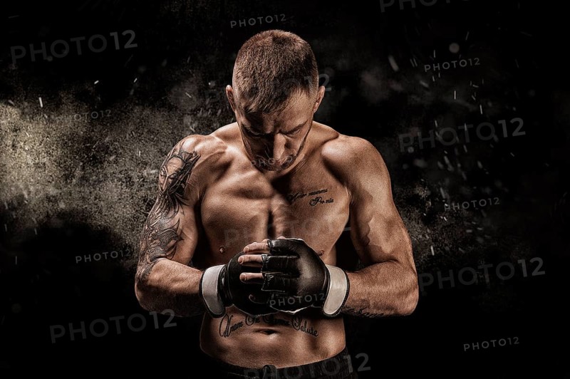 Mixed martial artist posing on a black background. Concept of mma