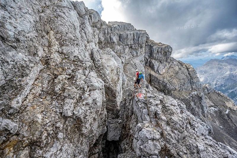 Mountaineer on a narrow rocky mountain path