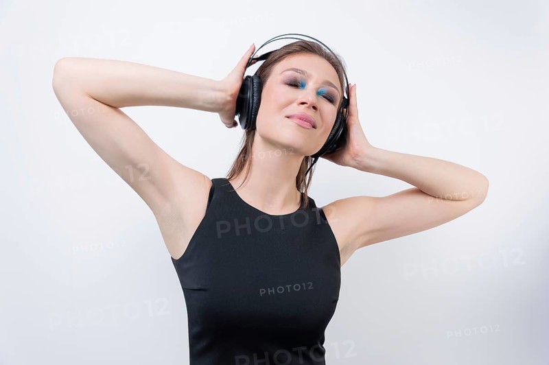 Portrait of a woman in headphones. Immersion in the world of music. DJ concept.