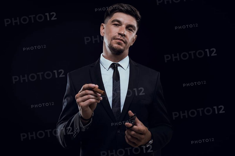 Portrait of a stylish man in a suit with a cigar. Business concept.