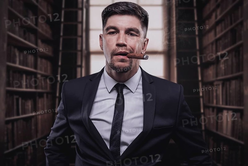 Portrait of a stylish man in a suit with a cigar. Business concept.