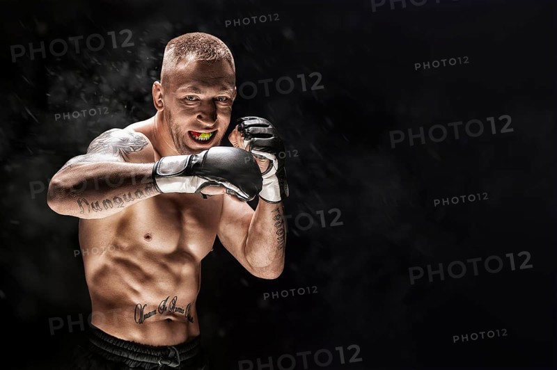 Mixed martial artist posing on a black background. Concept of mma