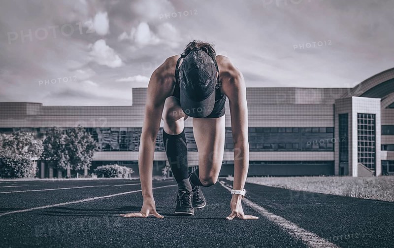 Professional runner stands on the track and prepares for the start of the race. Sports concept.