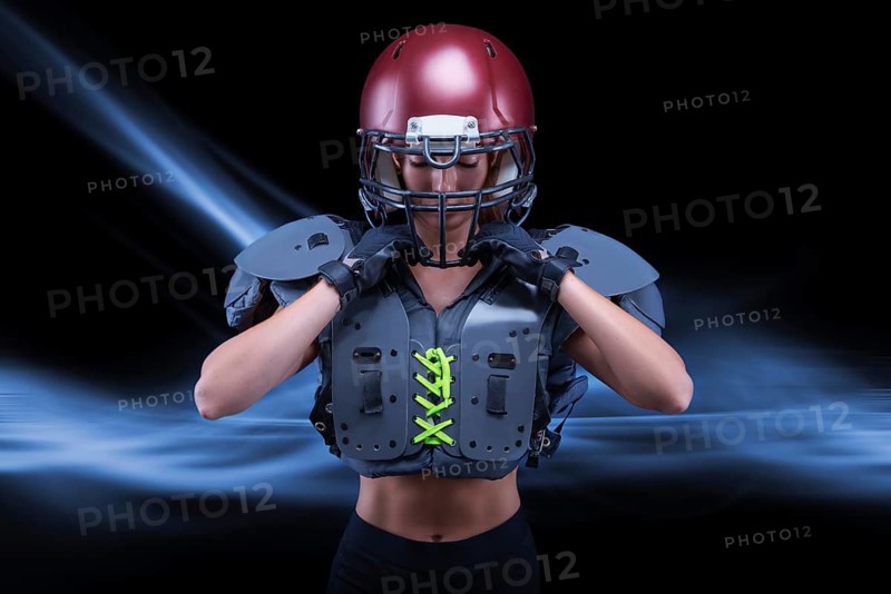 Brutal portrait of a girl in the uniform of an American football team player. Equipment advertising. Sports concept. Shoulder pads.