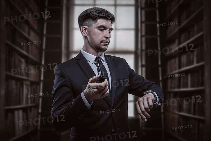 Portrait of an elegant man in a suit with a smoking pipe. Business concept.