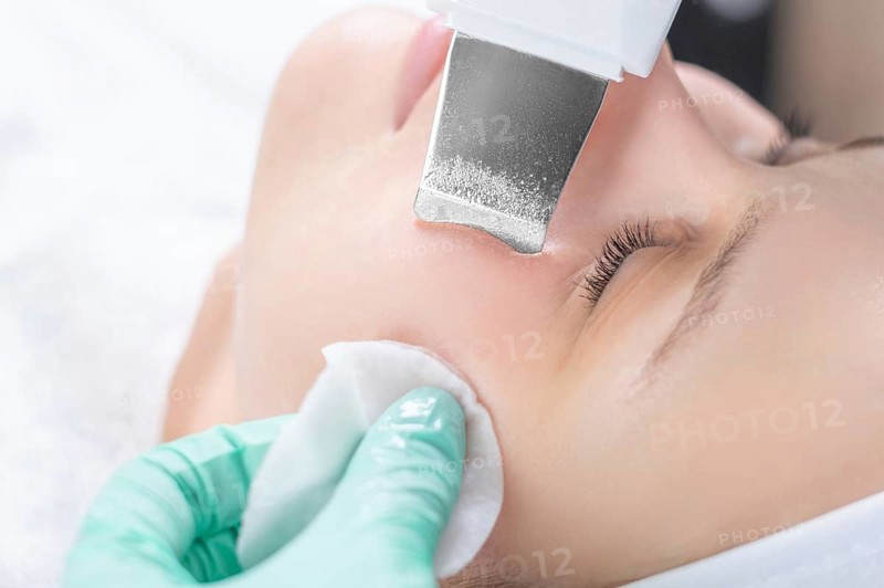 Young pretty woman receiving treatments in beauty salons. Ultrasonic cleaning procedure. Hardware cosmetology.