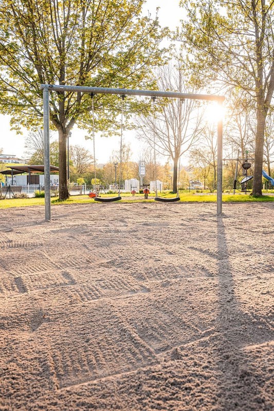 Sunny playground with swings and sandy area