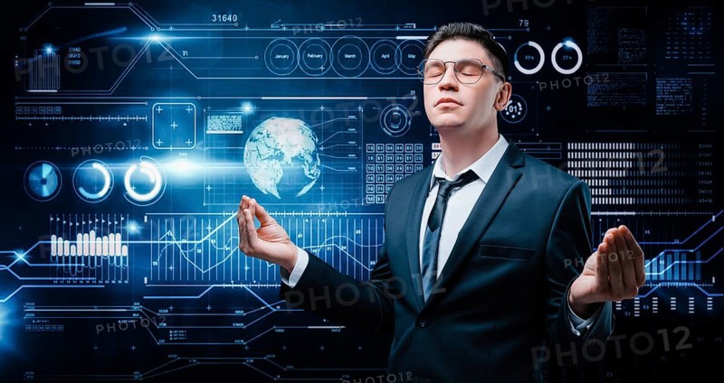 Confident man is standing in a business suit on the background of a stock exchange hologram. He is meditating. Stock broker and trader. Business investment.