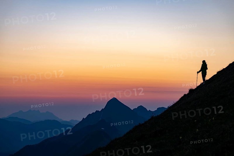 Mountaineer on mountain ridge with Rothorn peak in the background at blue hour