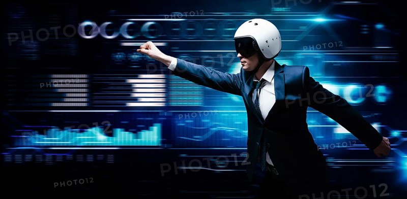 Portrait of a man in a suit and helmet. He shows that he is flying against the background of a hologram of market trading. Business concept. Stock market. Brokers and traders.