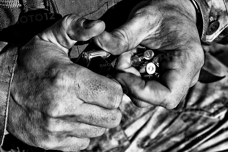 The fighter prepares a clip with bullets before the next fight.