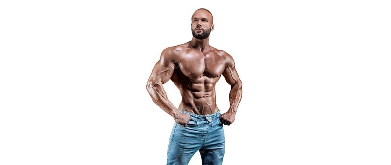 Sportsman posing on a white background in jeans. Fitness