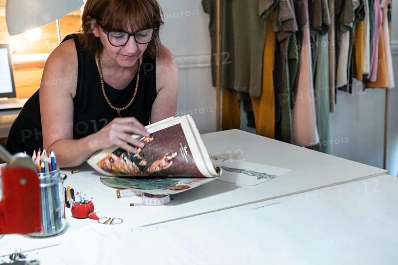 Mid adult fashion designer looking at a fashion magazine