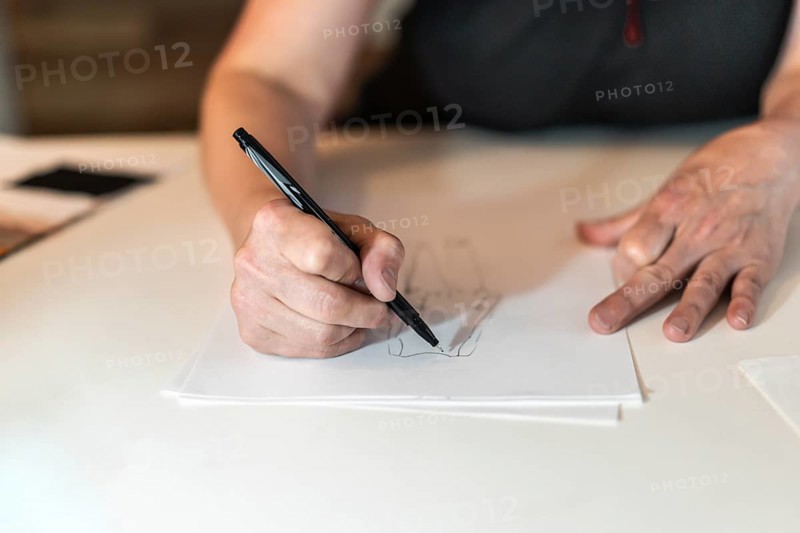 Close-up of a fashion desinger drawing with a pencil