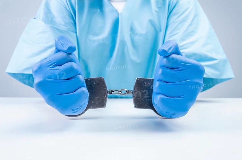 Hands of a doctor in handcuffs. The concept of corruption in medicine.