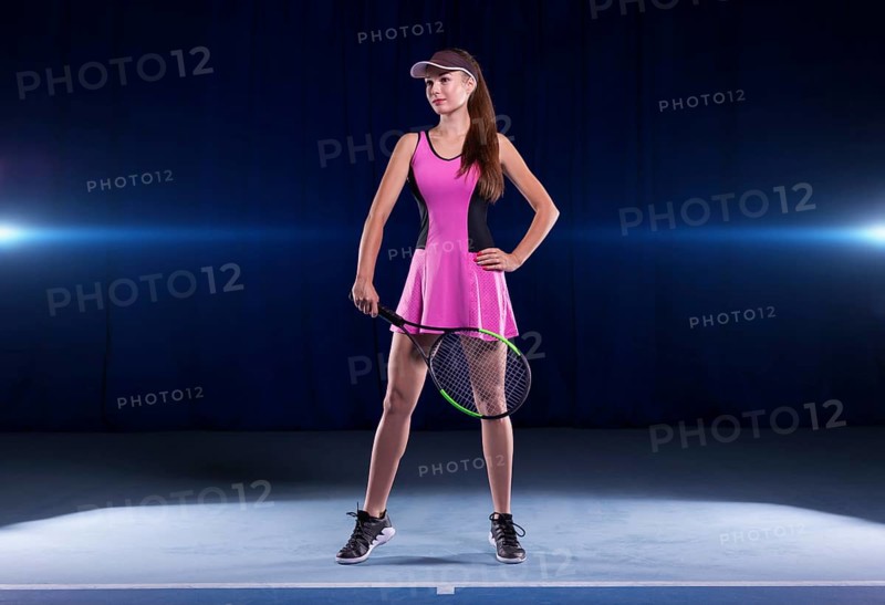 Portrait of a beautiful tennis player in a pink dress on the court. Sports concept.
