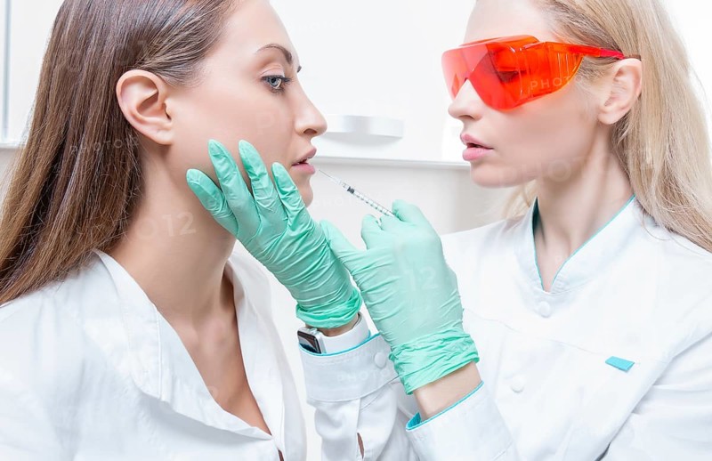 Portrait of two girls in white coats. The concept of cosmetology