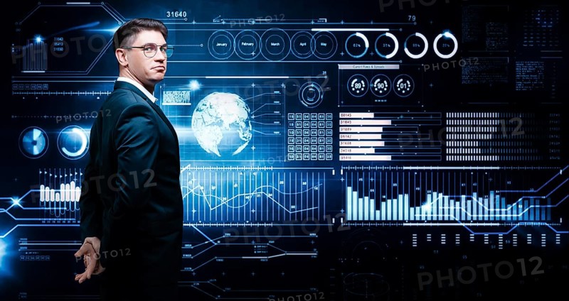Confident man is standing in a business suit on the background of a stock exchange hologram. Stock broker and trader. Business investment.