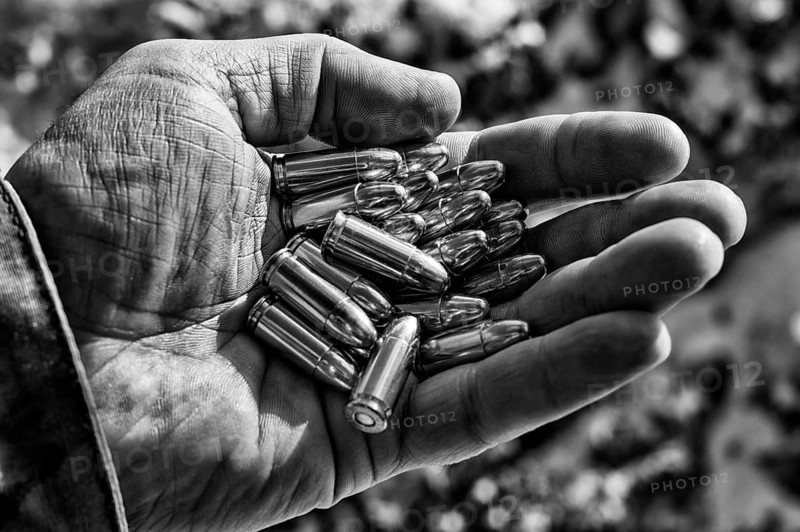 The fighter holds a handful of bullets in his palm for weapons.