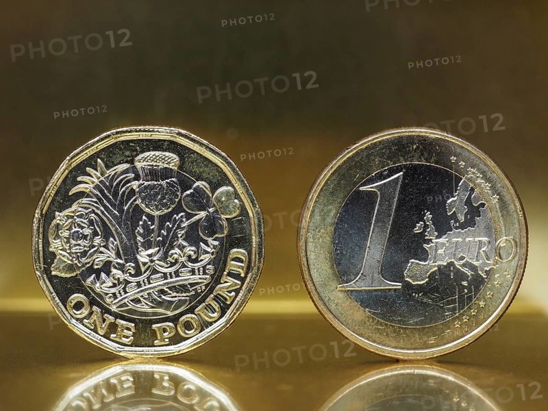 1 pound and 1 euro coin over metal background
