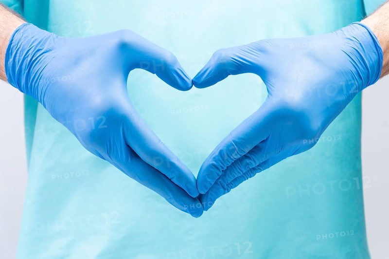 The doctor folded his hands in the shape of a heart. Medical concept.