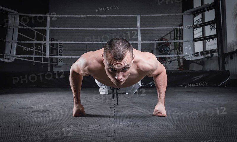 Muscular man doing push-ups in the gym. Fitness concept.