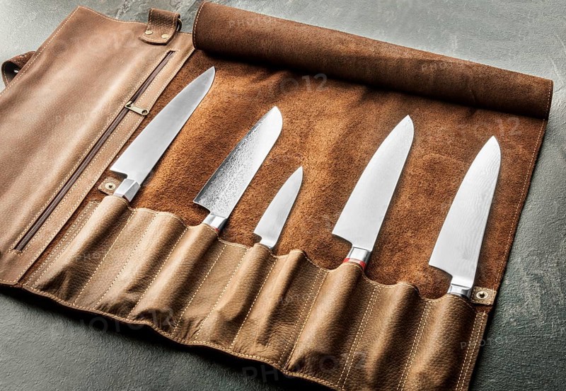 Japanese knives of different sizes from Damascus steel are in a leather case. Business concept of career growth
