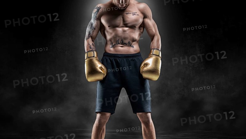 Professional Thai boxer stands in full combat gear. Muay Thai