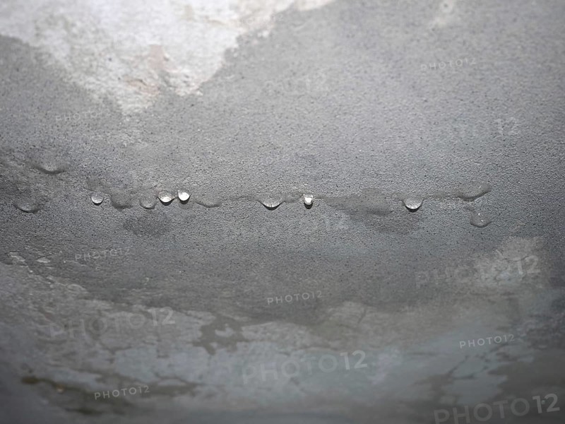 Dampness moisture on ceiling with drops of water infiltration