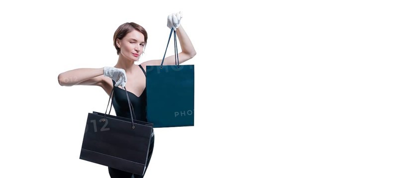 Stylish tall girl in white gloves demonstrates a black luxury package. The concept of safe shopping during a pandemic