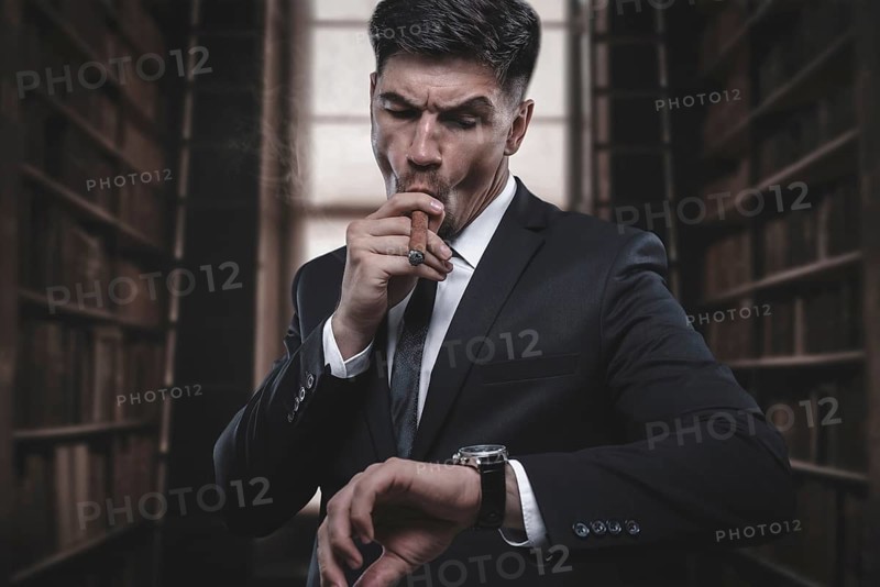 Portrait of a stylish man in a suit with a cigar. Business concept.