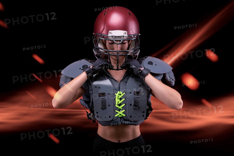 Brutal portrait of a girl in the uniform of an American football team player. Equipment advertising. Sports concept. Shoulder pads.