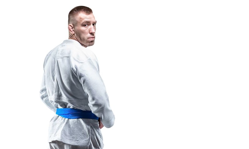 Strong man in a kimono looks over his shoulder. Concept of karate