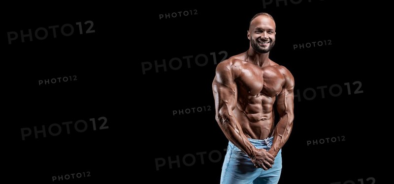 Isolated muscular man on a black background. Bodybuilding and fitness concept. Panorama.