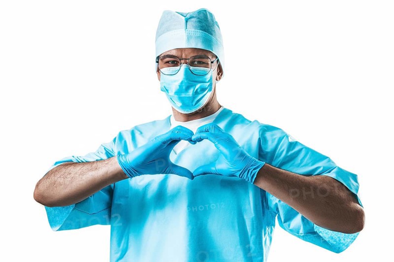 Portrait of a doctor on a white background. He folded his hands in the shape of a heart. Medicine concept.