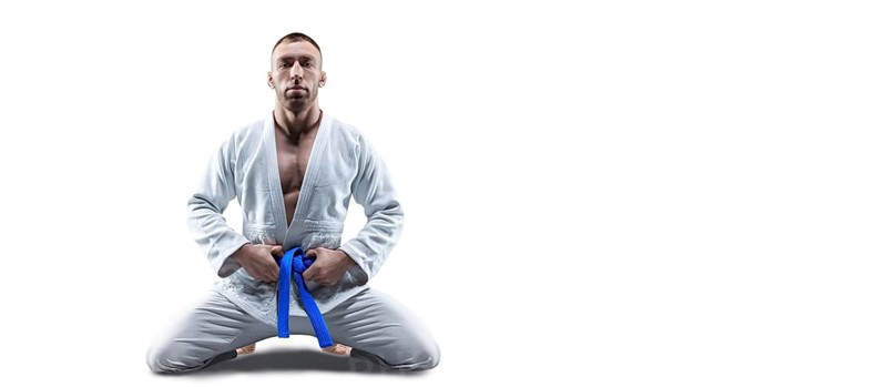 Athlete in a kimono with a blue belt sits and waits for the opponent. Concept of karate