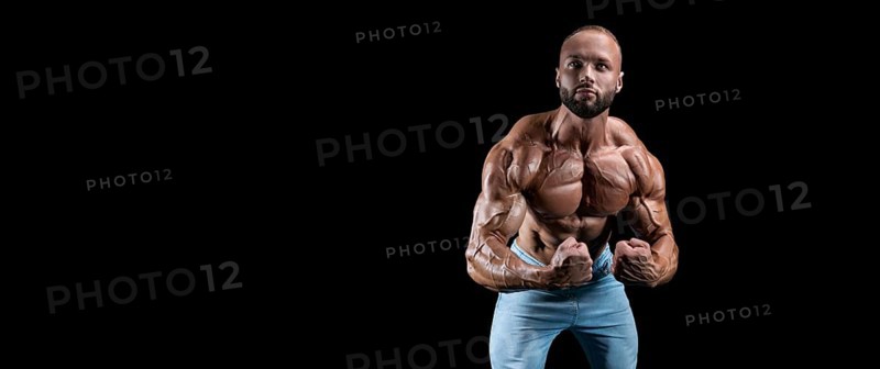 Isolated muscular man on a black background. Bodybuilding and fitness concept. Panorama.