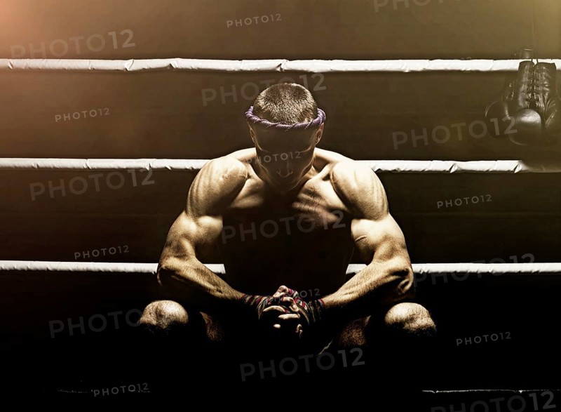 World champion in Thai boxing is sitting in the ring and getting ready for the next fight. The concept of sport